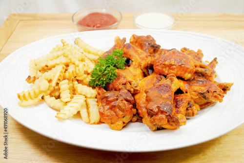 A Platter of French Fries Served and Spicy baked Buffalo Wings	