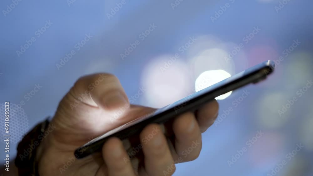 Hand scrolling social media feed on smart phone, close up