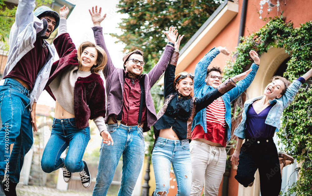 Fototapeta premium University college students jumping and cheering by end of school at campus yard - Trendy life style concept with young millenial friends having fun together out side - Backlight contrast filter