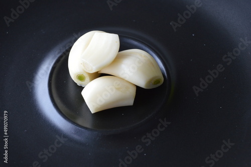 garlic cloves on a black plate