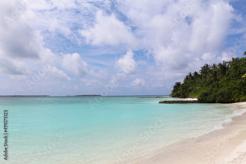 Fototapeta Naklejka Na Ścianę i Meble -  Maldives, a beach with the white sand near the turquoise ocean. Summer vacation on a paradise tropical island.