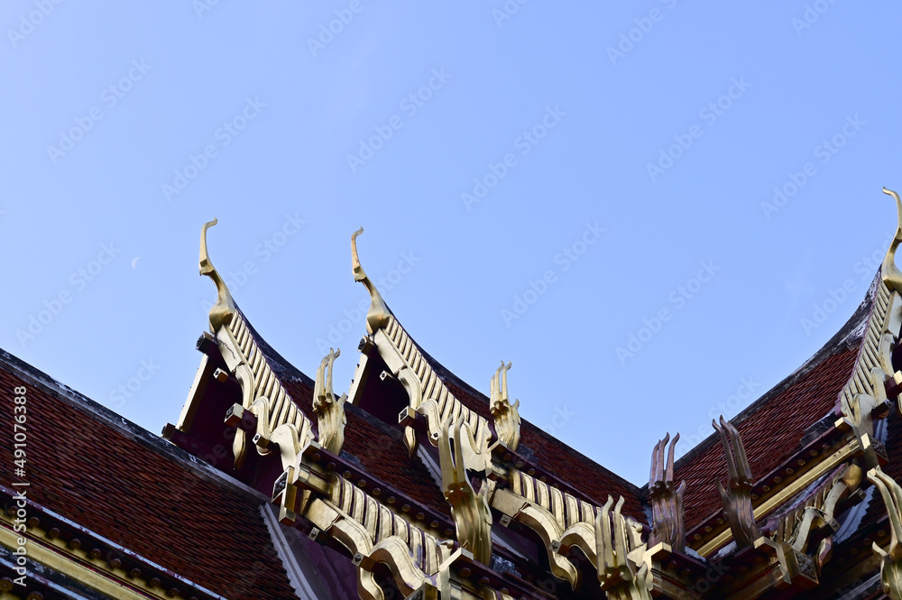 Part of the Roof of a temple in Thailand. Traditional Thai style pattern on the roof of a temple with Blue Sky Background.