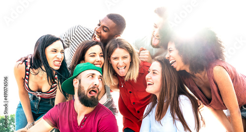 Multicultural millenial friends taking crazy selfie looking each other - Happy youth life style concept with international young guys and girls having fun together - Warm backlight filter