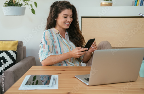 Happy Businesswoman Using Mobile Phone at Home Office