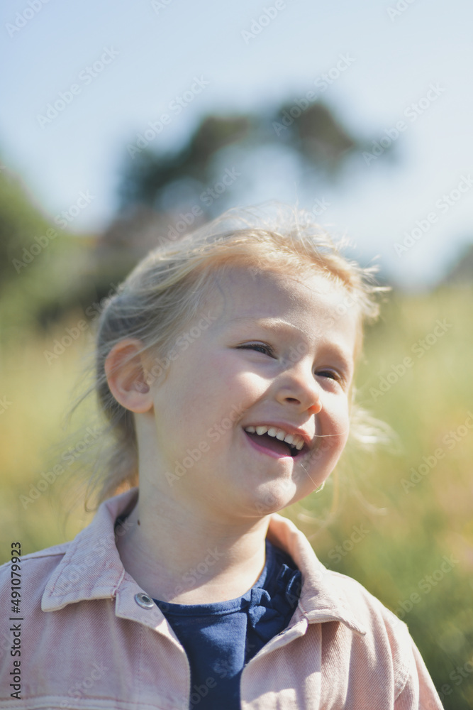 A five-year-old girl laughs outside in the summer A five-year-old girl laughs outside in the summer