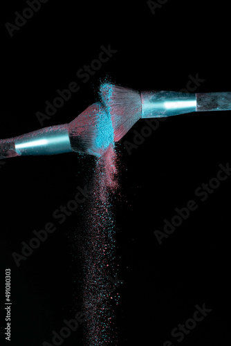 Make up brushes colliding together and exploding with powder