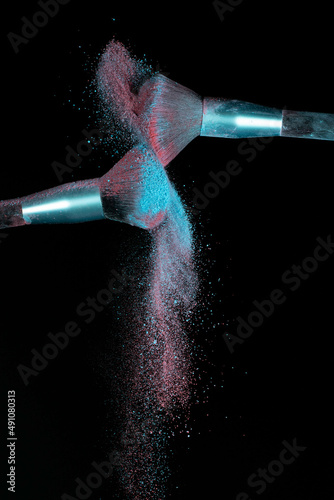 Make up brushes colliding and exploding with powder