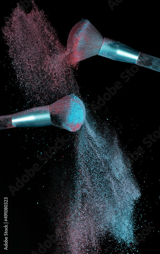 Make up brushes colliding together and exploding with powder