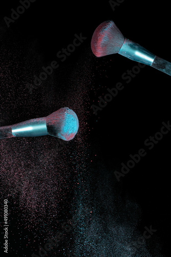 Make up brushes colliding together and exploding with powder