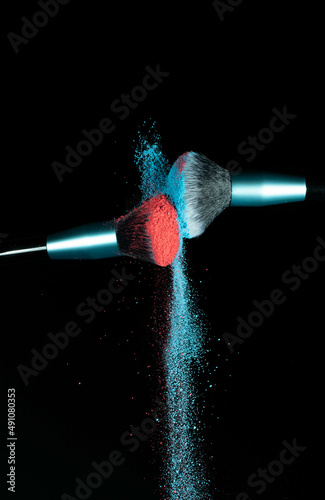 Make up brushes colliding together and exploding with powder