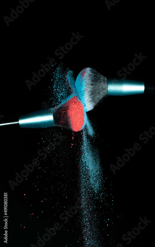 Make up brushes colliding together and exploding with powder