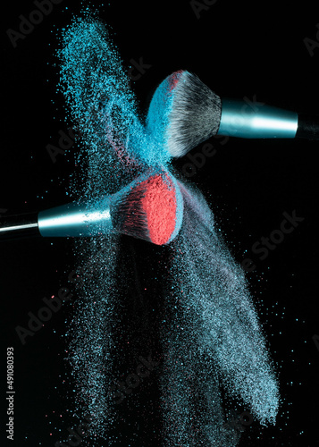 Make up brushes colliding and exploding with powder
