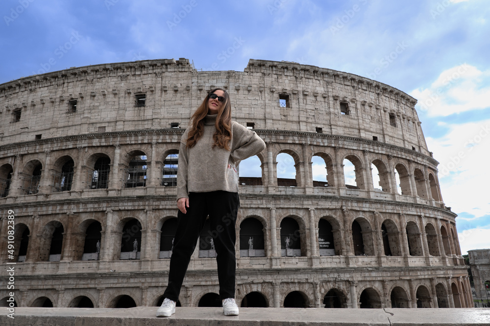 Tourist girl posing in front of Colosseum in Rome, Italy