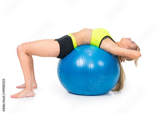 A shapely woman is exercising with a rehabilitation ball