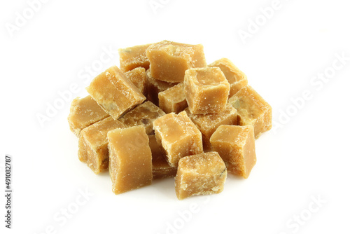 Pile of brown sugar cubes isolated on white background. Walnut nd milk fudge stack