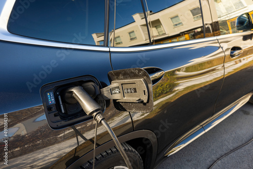 Close up view of an electric car charging in private parking lot. Sweden. © Alex