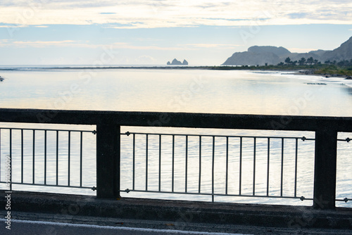 Bridge railing with view along Uawa River to coast photo