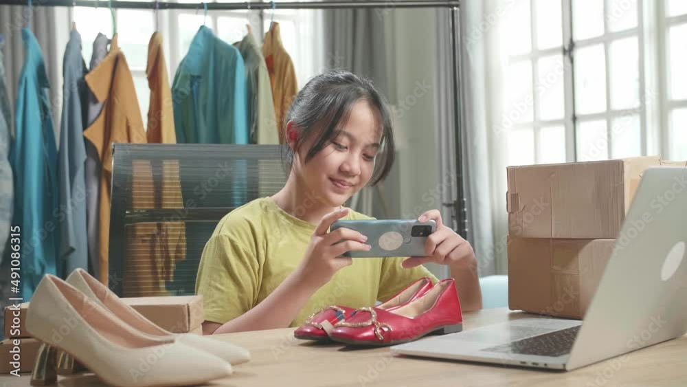 Asian Young Girl Online Seller Taking Photos With Mobile Phone While Using Computer For Selling Clothes At Home
Asian Young Girl Online Seller Taking Photos With Mobile Phone While Using Computer For Selling Clothes At Home