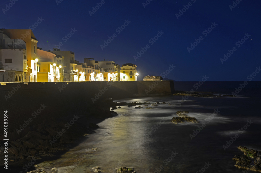 Night view of seafront bastions in Alghero, Sardinia, Italy