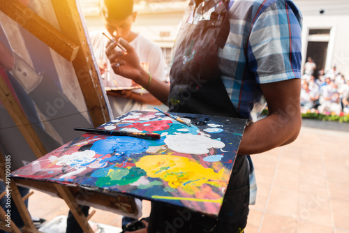 Young Latinos paint a work of art outdoors