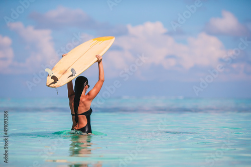 Beautiful surfer woman ready to surfing in turquoise sea, on stand up paddle board at exotic vacation © travnikovstudio