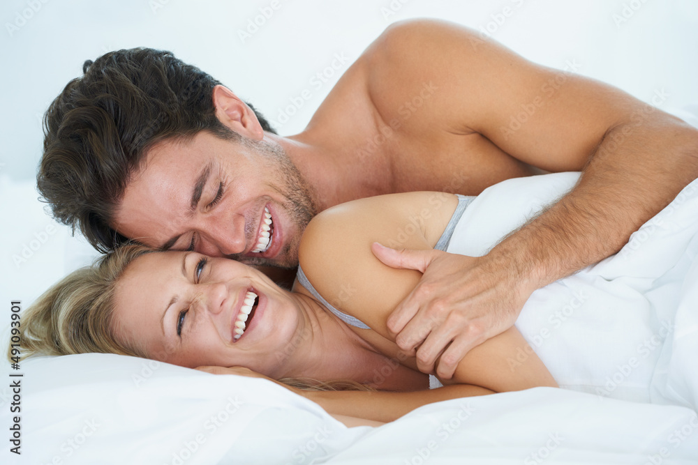 Magical mornings together. A husband embracing his wife affectionately while lying in bed together. Magical mornings together. A husband embracing his wife affectionately while lying in bed together.
