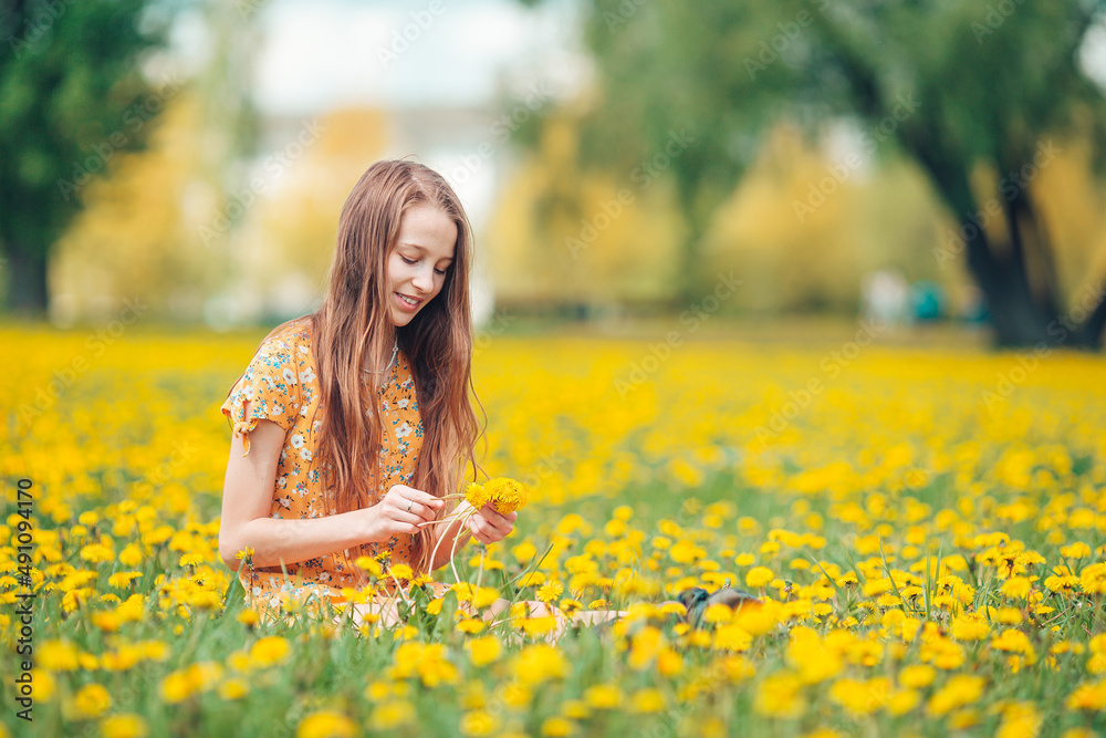 Little blonde girl pick flowers in a meadow full of yellow dandelions Little blonde girl pick flowers in a meadow full of yellow dandelions
