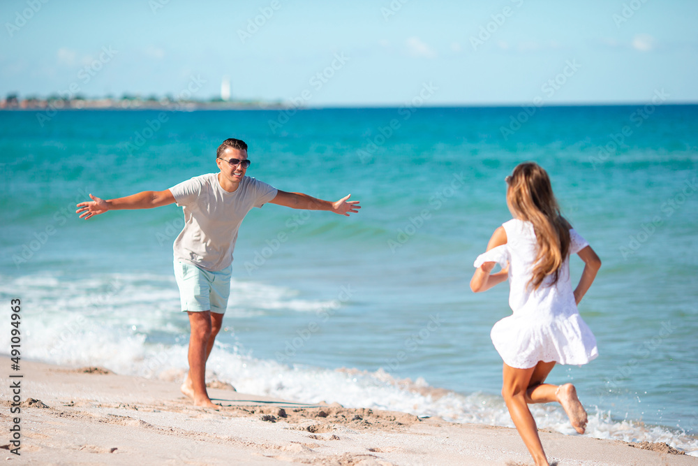 Little girl and happy dad having fun during beach vacation Little girl and happy dad having fun during beach vacation
