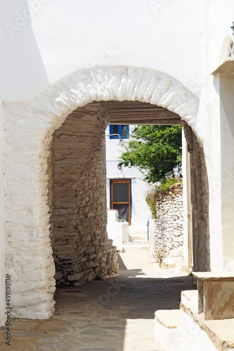 Fototapeta Naklejka Na Ścianę i Meble -  One of the charms of the Greek islands of the Cyclades (here, the island of Tinos), in the heart of the Aegean Sea, are the narrow streets: white houses, small flowered balconies and cobbled stairs