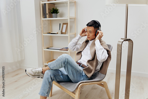 teenager sweater on the shoulders headphones music sitting in the room technologies © SHOTPRIME STUDIO