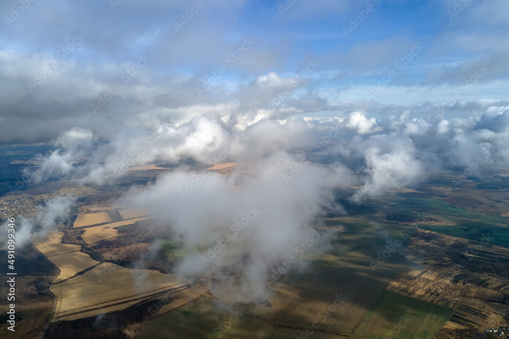 Aerial view from high altitude of earth covered with puffy rainy clouds forming before rainstorm Aerial view from high altitude of earth covered with puffy rainy clouds forming before rainstorm