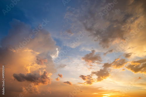 Fototapeta Naklejka Na Ścianę i Meble -  Dramatic sky at sunset with puffy clouds lit by orange setting sun