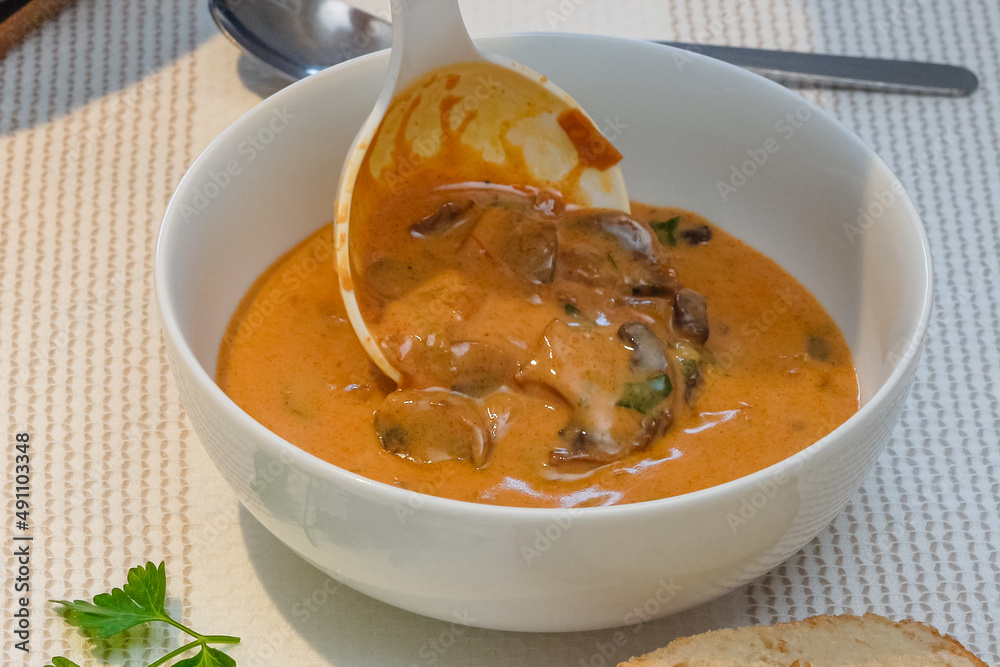Creamy mushroom soup in a glass bowl close up