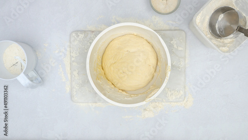 Raised bread dough in a bowl, view from above. Step by step cheese bread recipe, baking process