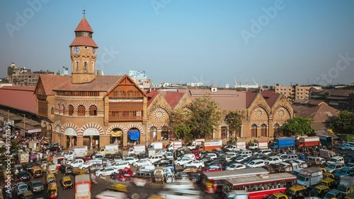 Time lapse view of rush hour traffic outside historic landmark Crawford Market in Mumbai, Maharashtra, India, zoom out. photo