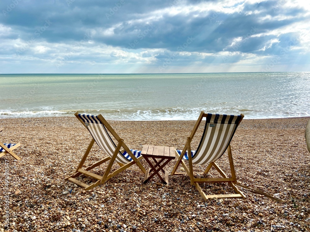 summer beach Deck chairs on seaside beach of summer seaside Hastings East Sussex Uk, sea sky and ocean waves behind summer beach Deck chairs on seaside beach of summer seaside Hastings East Sussex Uk, sea sky and ocean waves behind