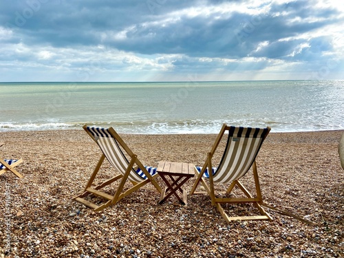 summer beach Deck chairs on seaside beach of summer seaside Hastings East Sussex Uk, sea sky and ocean waves behind © cheekylorns