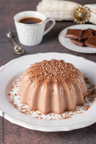 Dessert blancmange with chocolate sprinkled with chocolate chips on white plate