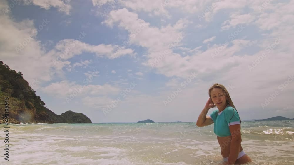 Crazy madwoman daring funny woman running and rolling on the sea. Happy slightly tipsy woman enjoying her vacation on a tropical island. Smiling girl funny posing. Concept summer holidays