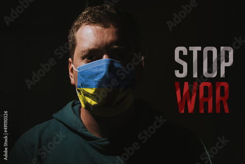 man with mask Ukraine flag with text stop war