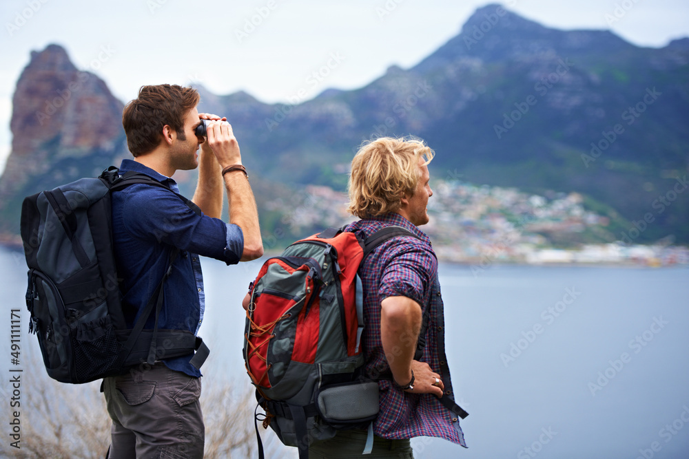 The view is unbelievable. Two male backpackers admiring a great view.