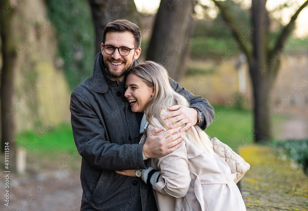 Happy young couple hugging and laughing outdoors. Happy young couple hugging and laughing outdoors.