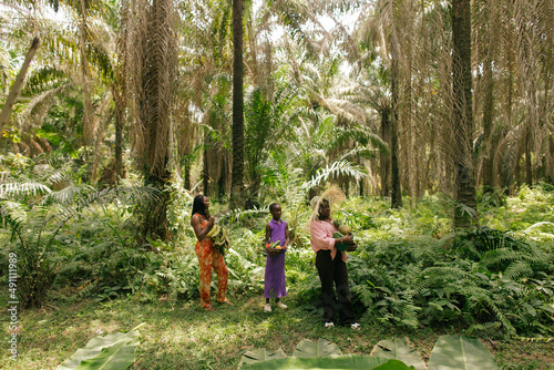 Landscape portrait of black african female activists holding their harvest in the rainforest together 