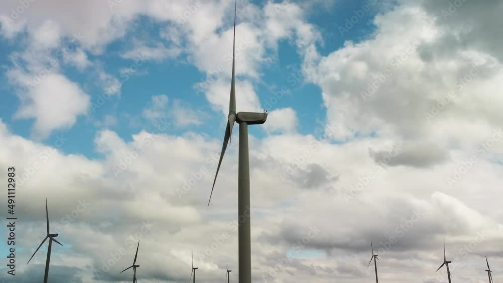 Aerial view over the farm landscape and wind turbines generating clean renewable energy. Renewable energy production for the green ecological world. High quality 4k footage Aerial view over the farm landscape and wind turbines generating clean renewable energy. Renewable energy production for the green ecological world. High quality 4k footage
