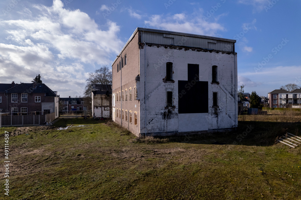 Partial structure of former industrial building waiting for demolition to make place for residential housing. Aerial real estate architecture repurpose urban development.