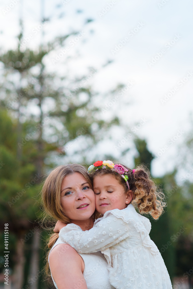 Obraz premium Daughter hugs her mother with feeling in the park outdoors