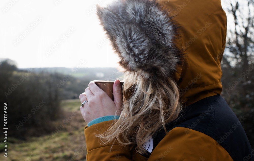 woman drinking hot drink on a cold day hiking woman drinking hot drink on a cold day hiking