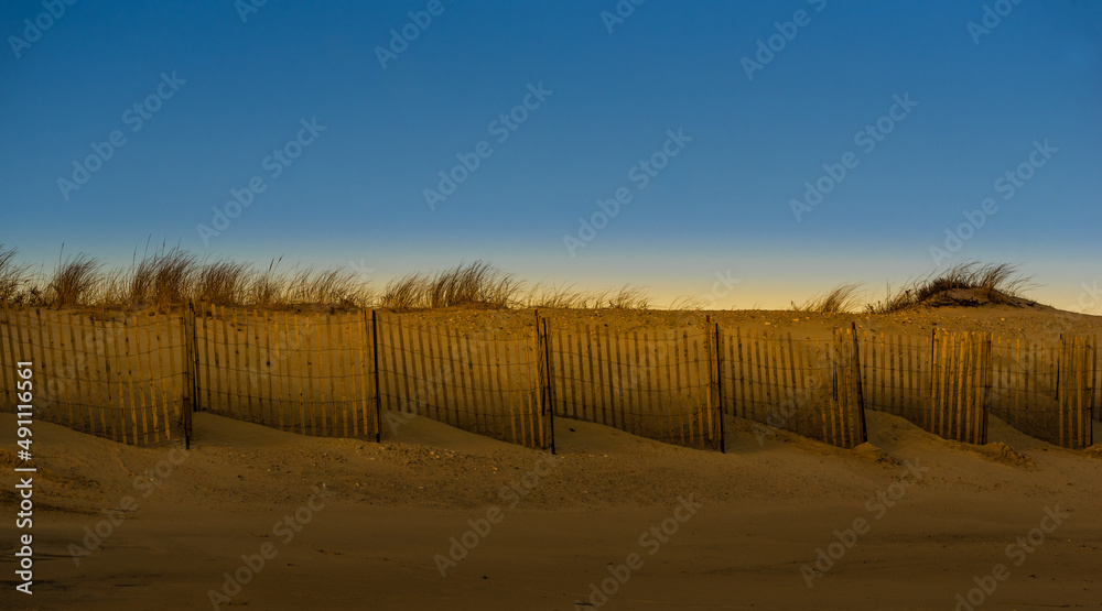 A fence in the beach field during the golden hour