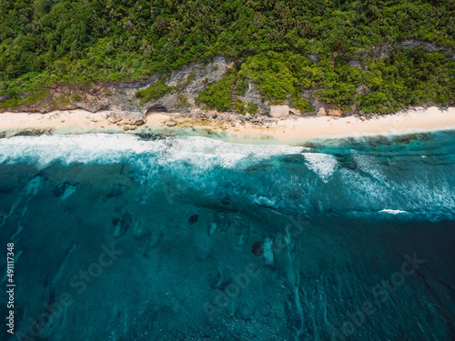 Tropical beach and transparent ocean with waves. Aerial view