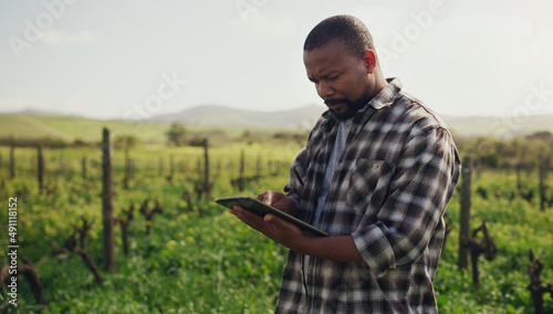 Farming just got a whole lot more efficient. Shot of a mature man using a digital tablet while working on a farm.